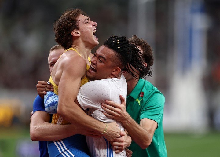 Emmanouil Karalis, Kurtis Marschall y Sam Kendricks abrazan a Duplantis para festejar que batió otro récord mundial. Sus rivales son sus fans.
Foto Reuters