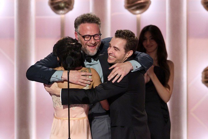 Zoë Kravitz y Dave Franco, que anunciaron el premio, abrazan a Seth Rogen. Foto AP 