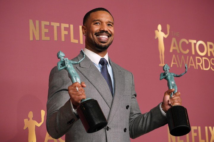 Michael B. Jordan posa con los dos premios a "Pecadores", el del mejor elenco y el suyo como mejor actor protagónico. Foto AP